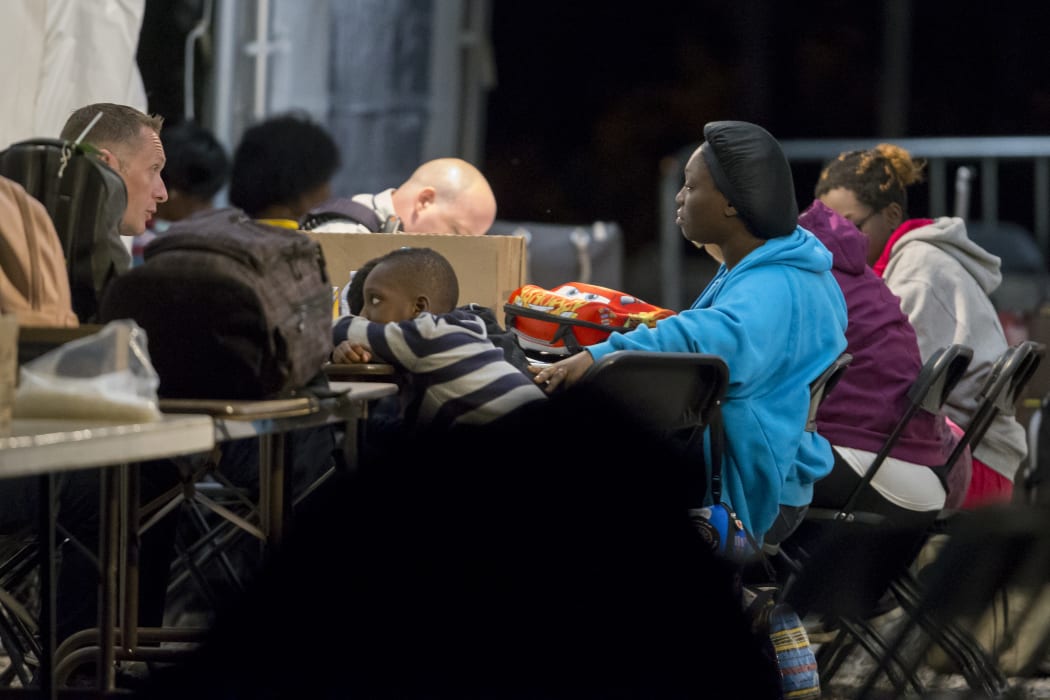 Refugees speak to Canadian officials at a processing centre after crossing the border from the United States