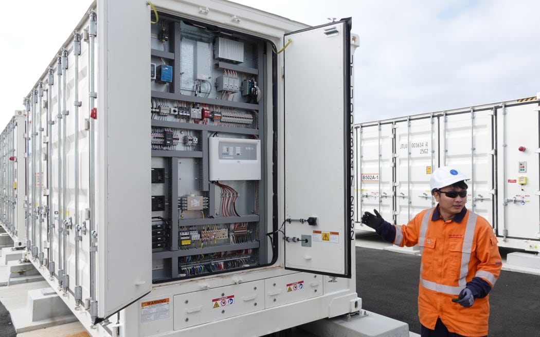 Saft field service engineer Minh Nguyen with one of the 80 containerised batteries that make up New Zealand's first grid-scale battery, on 23 May 2025.