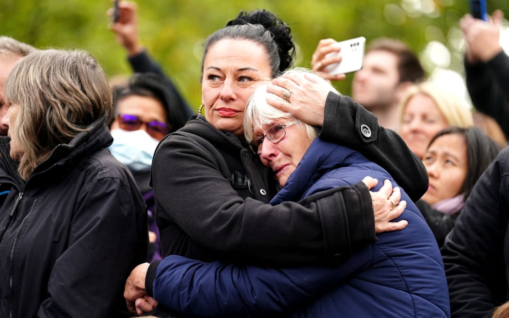 People embrace during the funeral of Queen Elizabeth II in London on September 19, 2022.