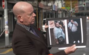 Detective Inspector Chris Barry holds an image of a man he says police are seeking in connection with the fatal shooting in Ponsonby.
