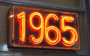 A neon sign saying "1965"