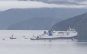 The Aratere ferry is seen grounded and surrounded by tug boats near Picton on 21 June 2024.