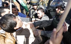 An Israeli border guard grabs Palestinian official Ziad Abu Ein (L) during a demonstration in the village of Turmus Aya near Ramallah, on 10 December 2014.