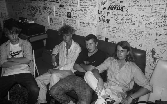 Black and White photo of four young men sitting on a couch