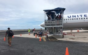 The Marshall Islands on Friday indefinitely banned all overseas travel by government employees and elected leaders in an effort to reduce opportunities for the importation of the new coronavirus. Pictured: Passengers boarding a United Airlines flight in Majuro.
