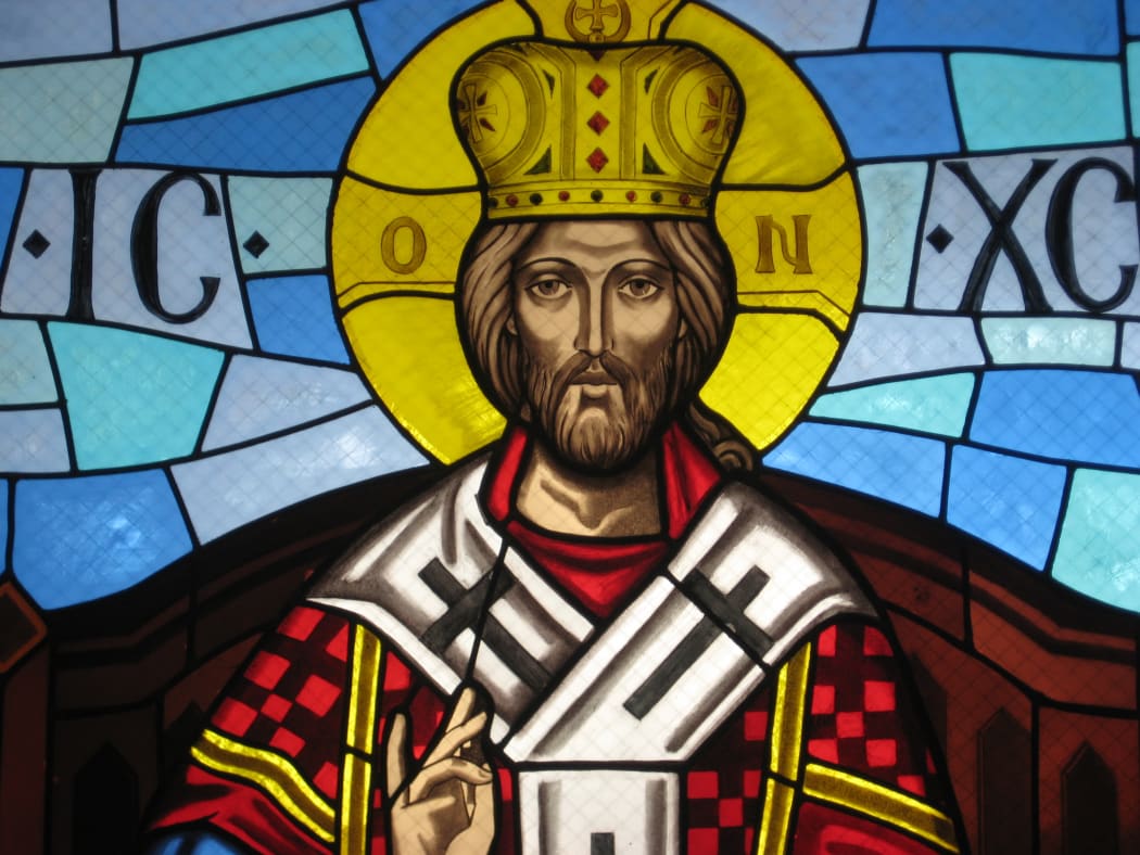 Christ depicted as a king with a crown. Stained glass window.