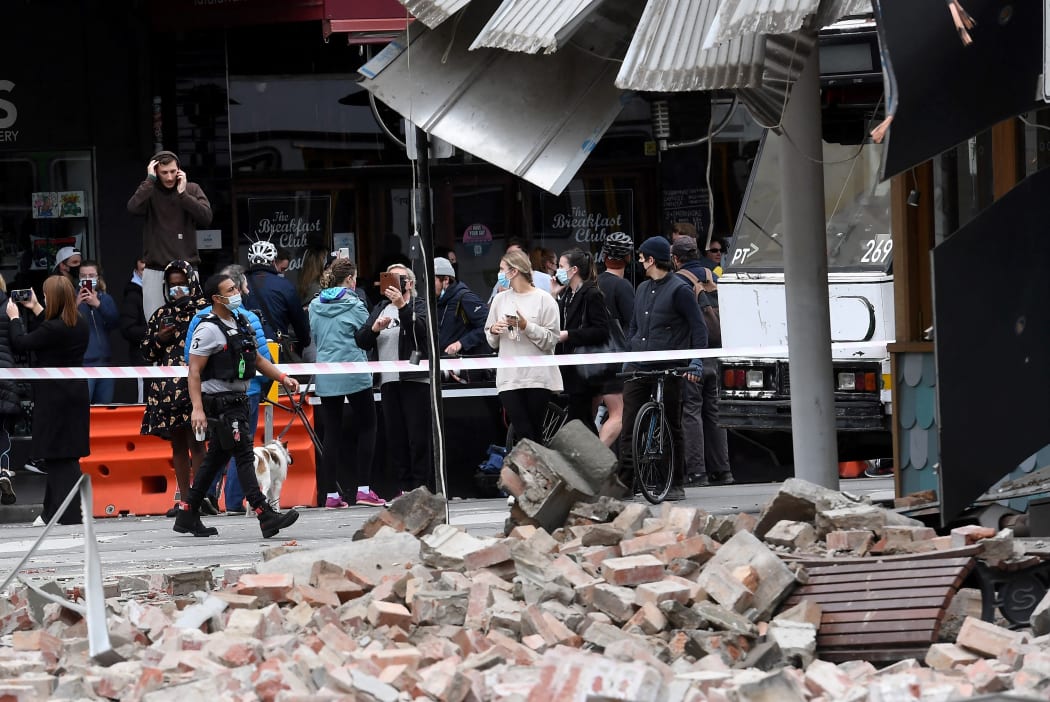Residents gather near a damaged building in the popular shopping Chapel Street in Melbourne on September 22, 2021, after a 5.8-magnitude earthquake.