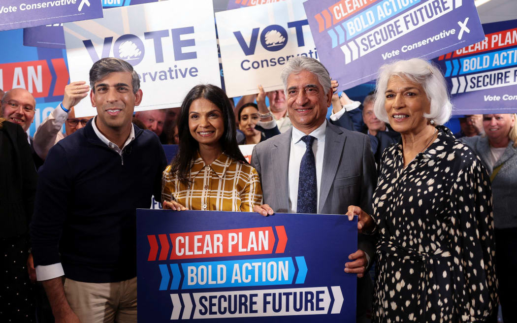 Conservative Party leader Rishi Sunak, his wife Akshata Murty and his parents Usha and Yashvir Sunak pose during his final rally at Romsey Rugby Football Club in Hampshire on 3 July. (Photo by Claudia Greco / POOL / AFP)