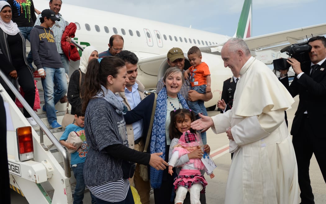Pope Francis welcomes a group of Syrian refugees after landing in Rome following a visit at the Moria refugee camp.