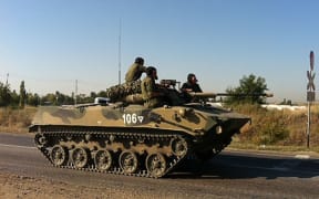 A Russian military vehicle moves along a road near the Ukrainian border on 15 August.