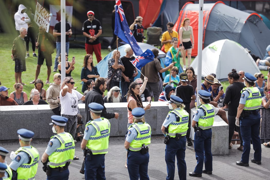Police form a line around protesters at Parliament.