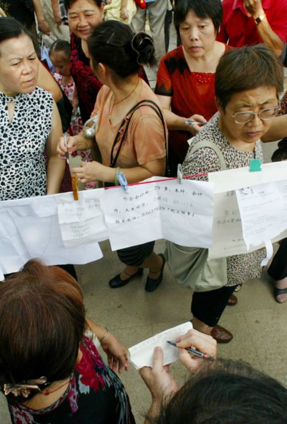 Parents seeking marriage partners for their children inspect handwritten spouse-seeking papers displayed at Zhongshan Park in the city of Wuhan in China's Hubei province.