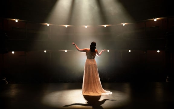 View from behind of an opera singer performing on stage.