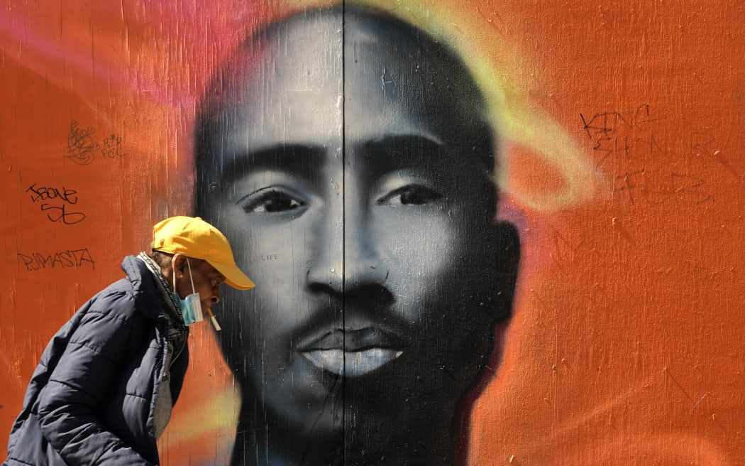 A man walks by a mural of the late rapper Tupac Shakur in the Harlem area of  New York City on May 5, 2020. (Photo by TIMOTHY A. CLARY / AFP)