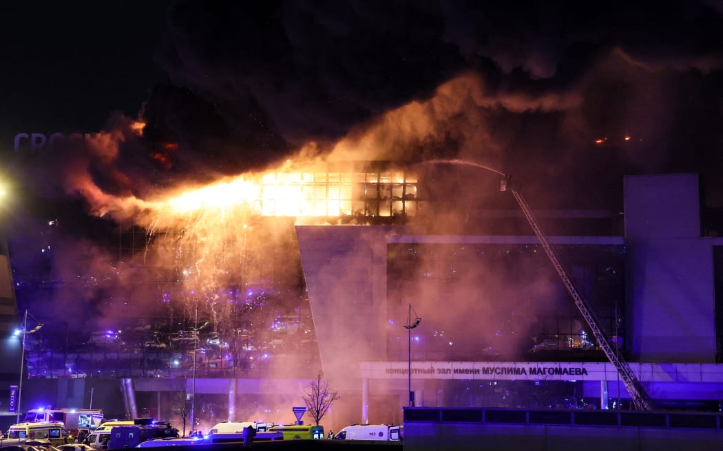 A view shows the burning Crocus City Hall concert hall following the shooting incident in Krasnogorsk, outside Moscow, on March 22, 2024. Gunmen opened fire at a concert hall in a Moscow suburb on March 22, 2024 leaving dead and wounded before a major fire spread through the building, Moscow's mayor and Russian news agencies reported. (Photo by STRINGER / AFP)