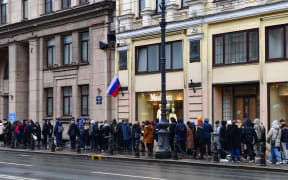 People queue outside a polling station during Russia's presidential election in Saint Petersburg on March 17, 2024. Russian opposition has called on people to head to the polls on March 17, 2024, at noon, in large numbers to overwhelm polling stations, in a protest which they hope will be a legal show of strength against President Vladimir Putin. (Photo by Olga MALTSEVA / AFP)