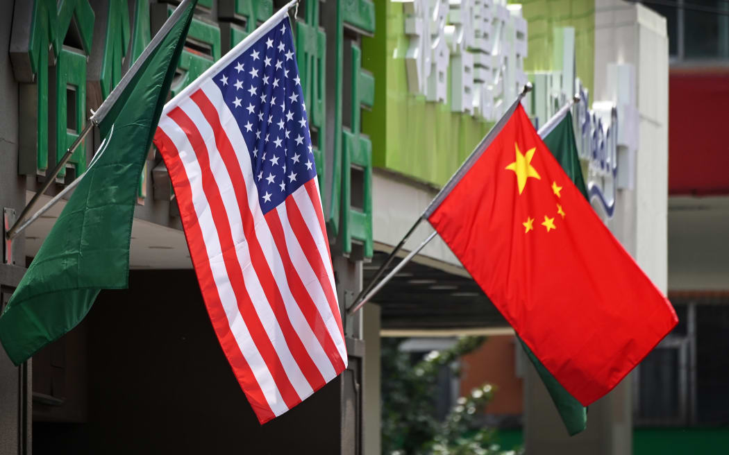 The US (L) and Chinese flags are displayed outside a hotel in Beijing on May 14, 2019. - Beijing's latest retaliation against US tariff hikes -- an increase on $60 billion of US imports from June 1 -- could leave China running low on ammunition in the trade war. (Photo by Greg Baker / AFP)