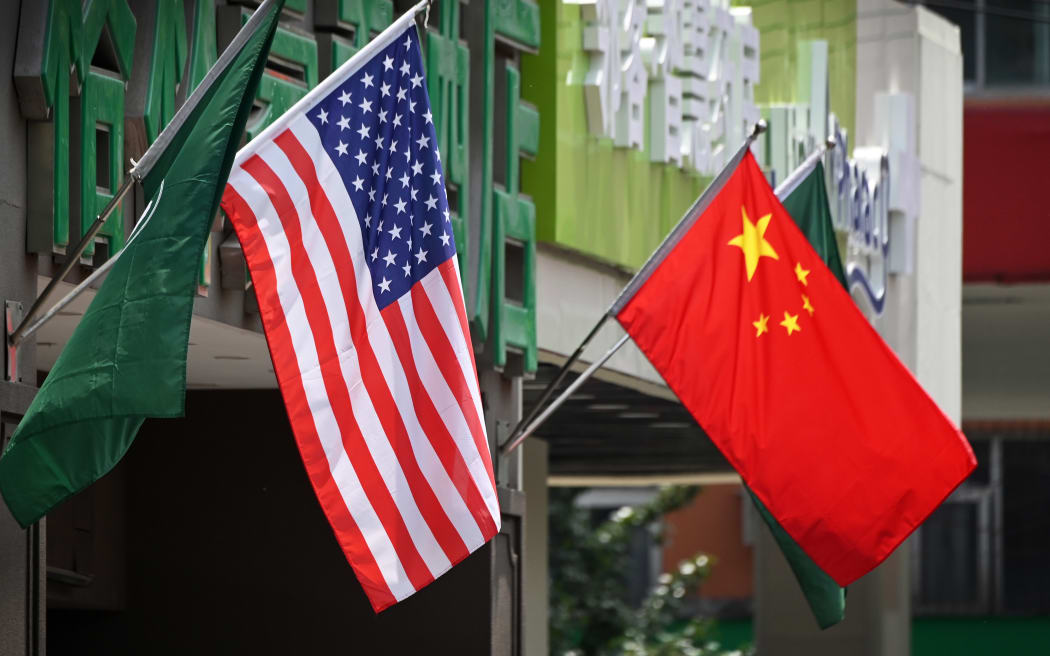 The US (L) and Chinese flags are displayed outside a hotel in Beijing on May 14, 2019. - Beijing's latest retaliation against US tariff hikes -- an increase on $60 billion of US imports from June 1 -- could leave China running low on ammunition in the trade war. (Photo by Greg Baker / AFP)