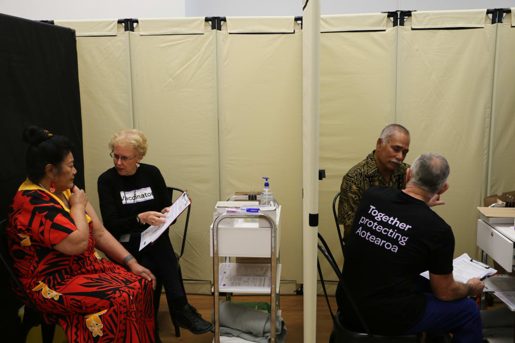 Malia Su-emalo Lui (left cubicle) and Seumanu Va'a Robertson (right) receive information about Covid-19 vaccination before receiving the jab at a public vaccination event arranged by the Catholic Church in Wellington, 9 June 2021.