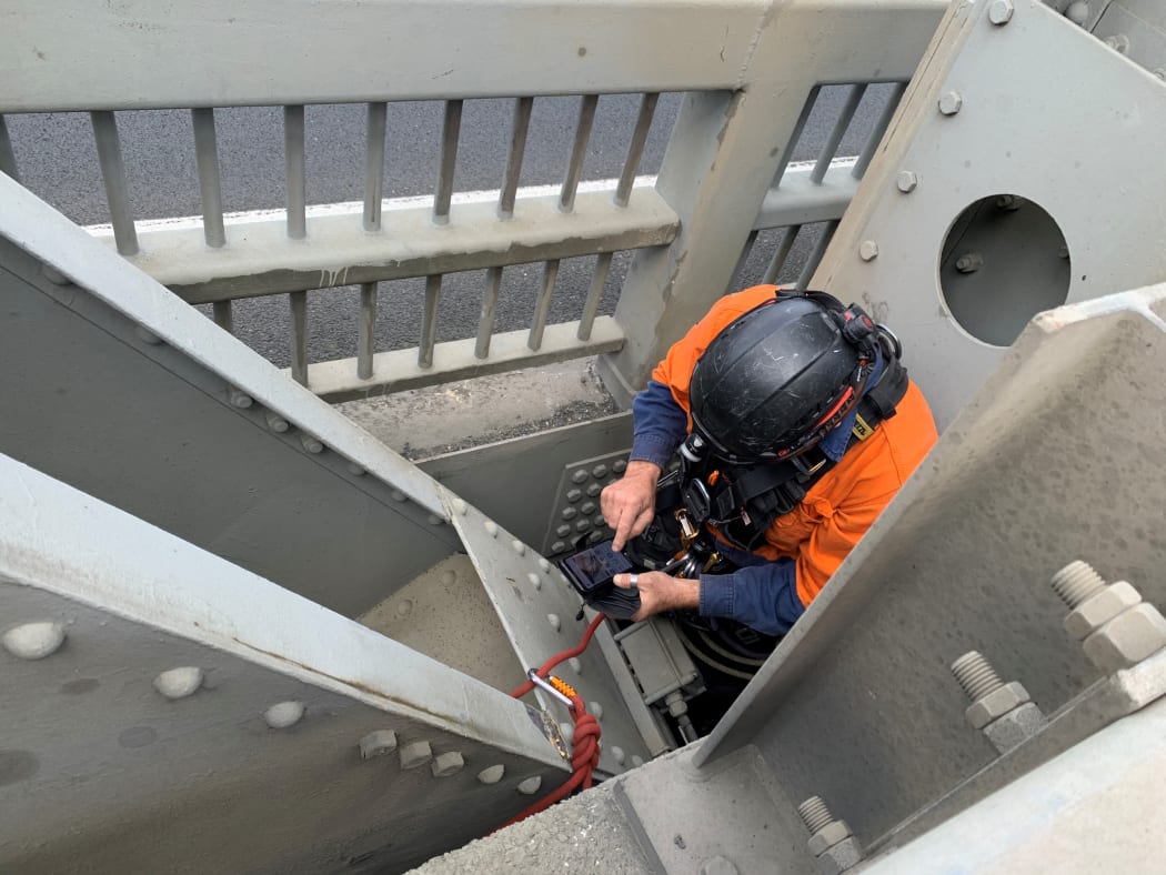 Taking photos of damage underneath the bridge.