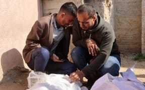 Mourners gather by the shrouded bodies of victims killed in a bombardment in Beit Lahia in the northern Gaza Strip, outside an Indonesian hospital on 15 March, 2025.
