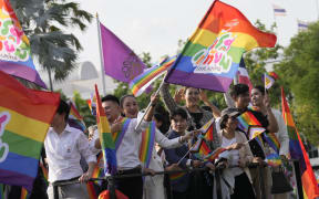Participants wave flags celebrating equality in marriage at government house in Bangkok, Thailand, Tuesday, June 18, 2024. Thailand's Senate voted overwhelmingly on Tuesday to approve a marriage equality bill, clearing the last legislative hurdle for the country to become the first in Southeast Asia to enact such a law. (AP Photo/Sakchai Lalit)