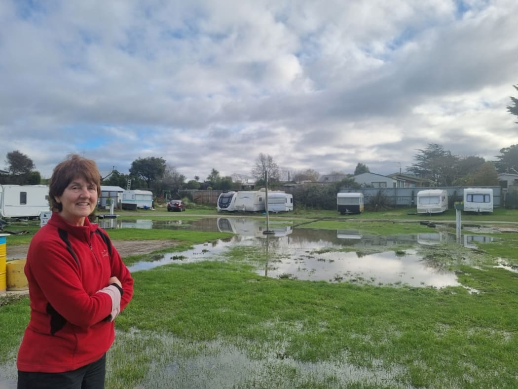 Waikuku Beach Holiday Park owner Debbie Jefcoate and the pooling floodwaters at the park.