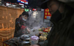 A food seller waits for clients at a market in Wuhan, China's central Hubei province this month.