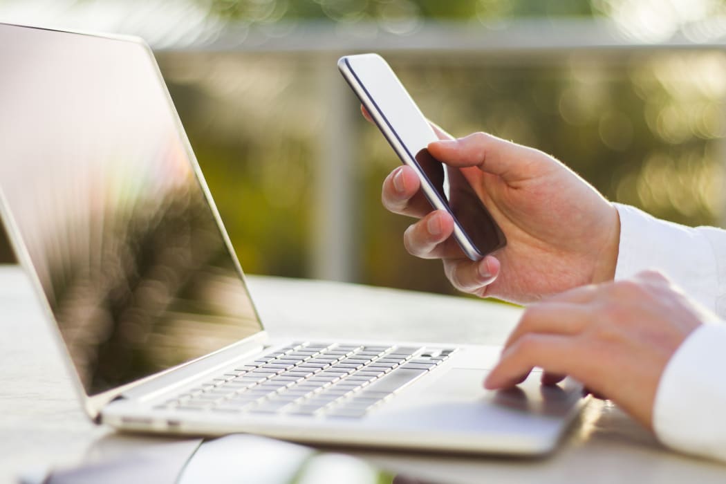 businessman with cellphone and laptop at morning
