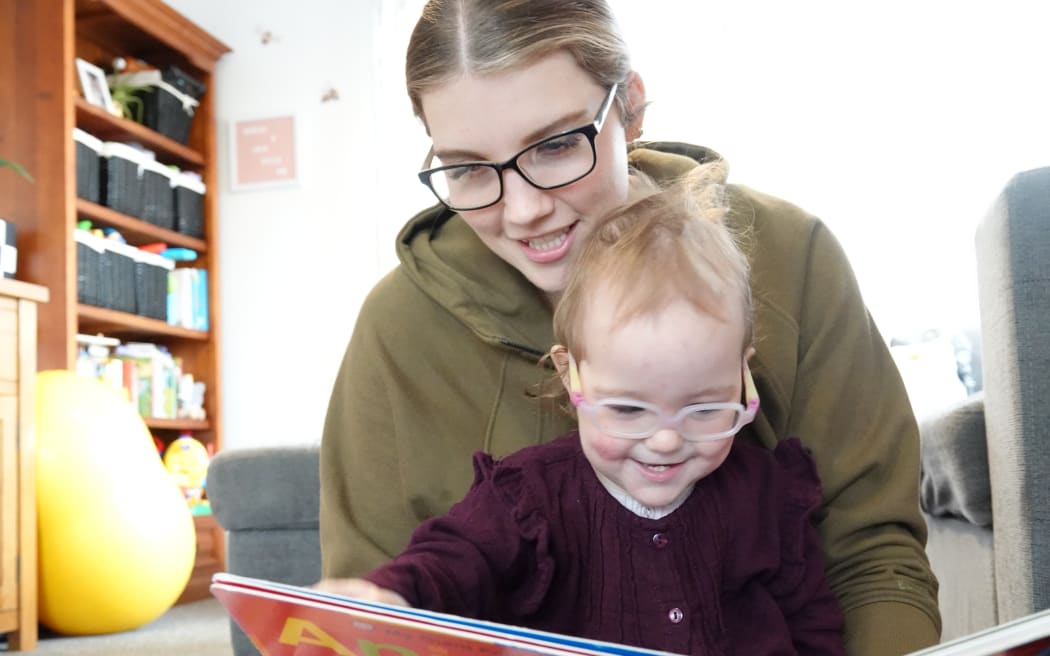 Nikita Tiffen reads to her daughter Julia.