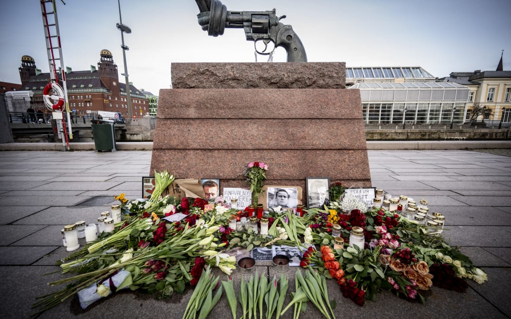 Flowers, candles and portraits of late Russian opposition leader Alexei Navalny, who died in a Russian Arctic prison, lay at a makeshift memorial at Carl Fredrik Reutersward's sculpture 'Non-Violence' at Anna Lindhs Place in Malmo, Sweden on February 20, 2024.