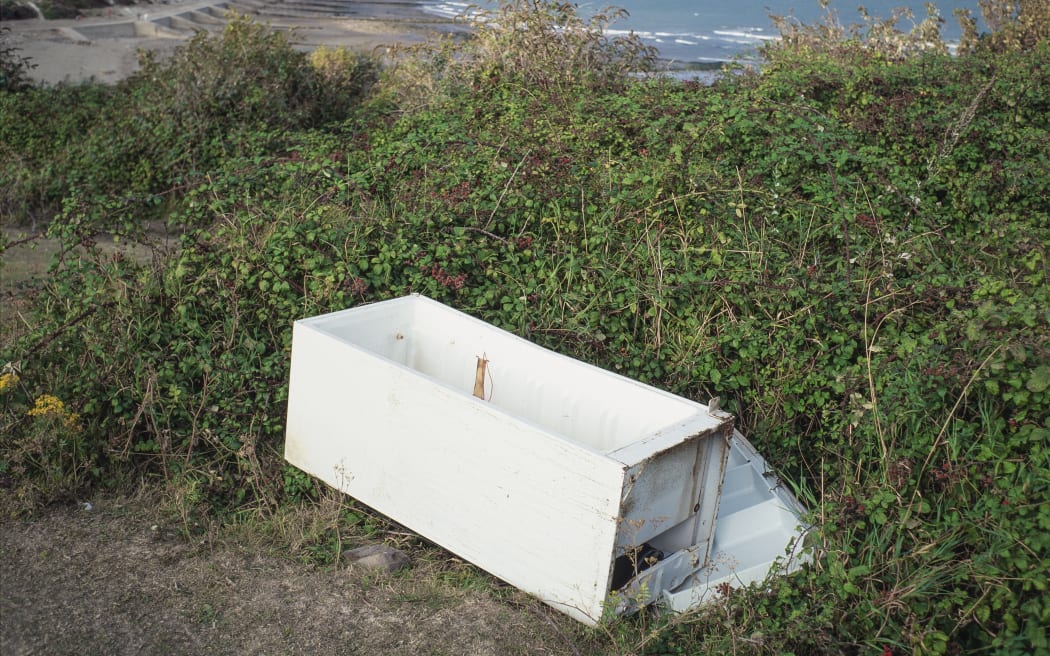 Dumped refrigerator and view of chalk cliffs between Folkestone and Dover, UK. (Photo by ROBERT BROOK/SCIENCE PHOTO LIBRA / RBR / Science Photo Library via AFP)