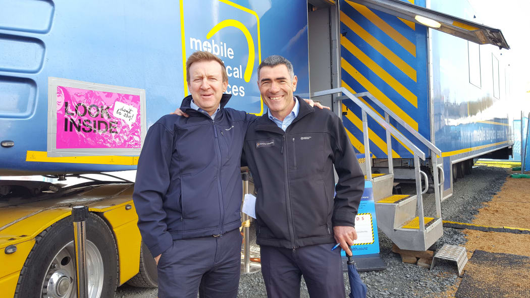 Jonathan Coleman and Nathan Guy outside the mobile surgical unit.