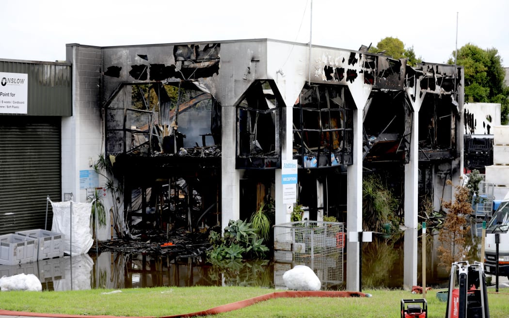 Fire crews at the scene of a recycling plant the day after a large fire engulfed the industrial building in Auckland's North Shore.