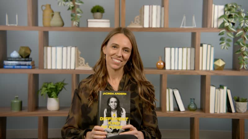 Jacinda Ardern holds a copy of her memoir, A Different Kind of Power.