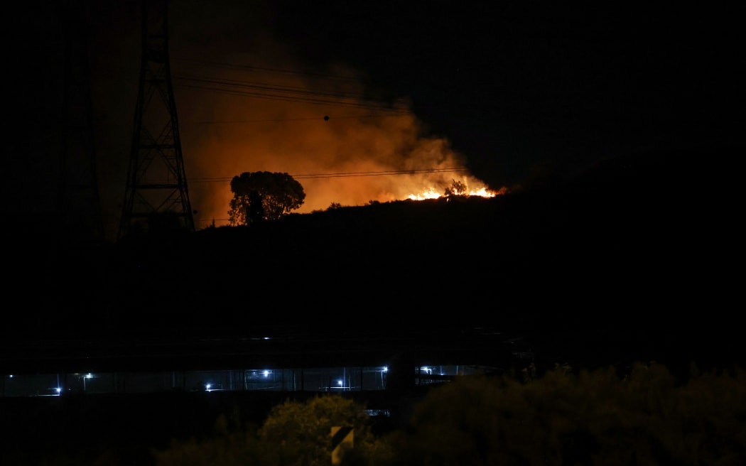 Fire erupts between Ben Gurion International Airport near Tel Aviv and the city of Modiin following an Iranian missile attack, on October 1, 2024. Iran's Revolutionary Guards said a missile attack under way against Israel on October 1 was in response to the killing of Hezbollah chief Hassan Nasrallah last week as well as that of the Hamas leader. (Photo by Ahmad GHARABLI / AFP)