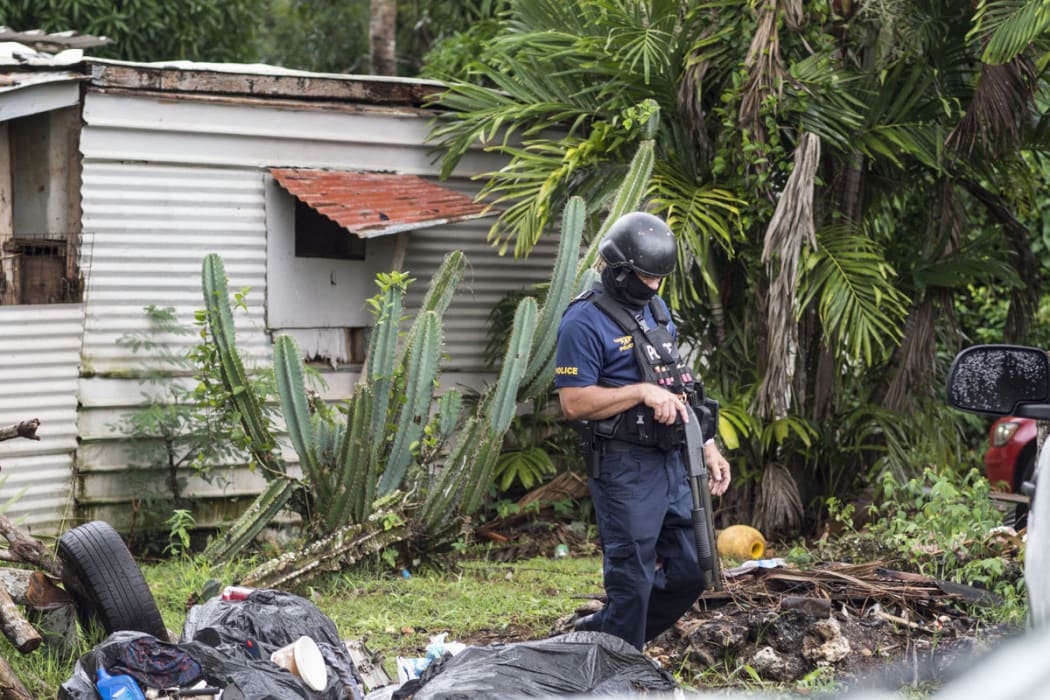 Guam SWAT officer executing a search warrant at a residence on Matsumiya Street in Mangilao in June.