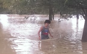 A young man in flood waters on the Kapiti Coast.