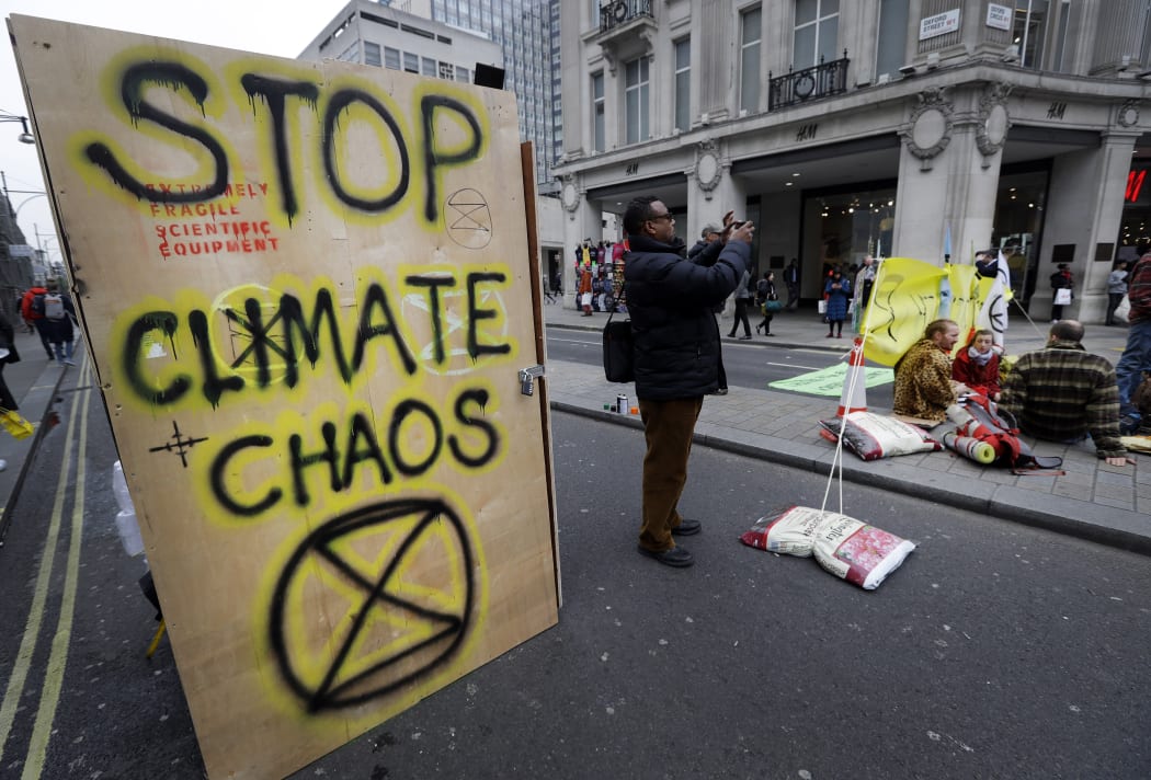 Writing on the side of a temporary toilet set up as the road is blocked during a climate protest at Oxford Circus in London, 16 April, 2019.