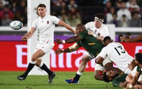 South Africa's hooker Bongi Mbonambi passes the ball past England's flanker Tom Curry (2nd R) as he is tackled by England's centre Manu Tuilagi (bottom R).