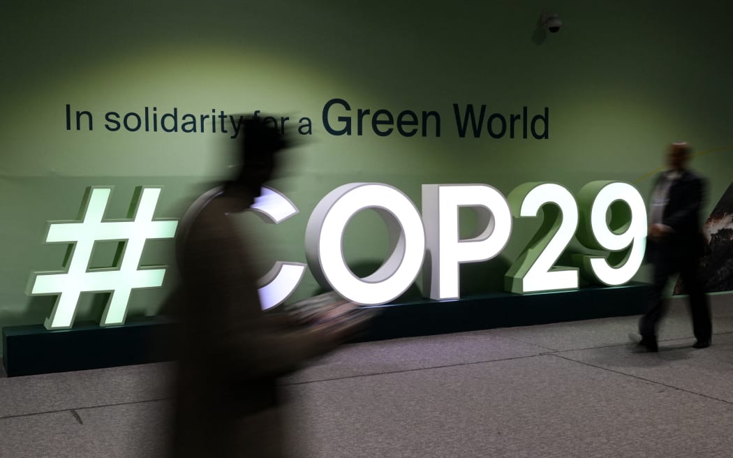 Attendees walk past the COP29 logo during the United Nations Climate Change Conference (COP29) in Baku, Azerbaijan, on 21 November 21, 2024.