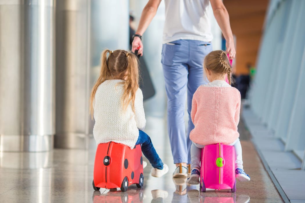 Children at airport with suitcases