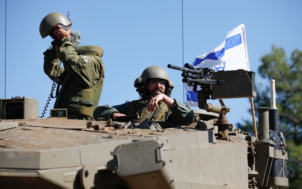 Israeli soldiers sit on a Merkava tank as they man a position at an undisclosed location on the border with Lebanon on October 21, 2023. Lebanon's Iran-backed Hezbollah and allied Palestinian factions have traded cross-border fire with Israel for days, after Hamas gunmen attacked communities in southern Israel on October 7.