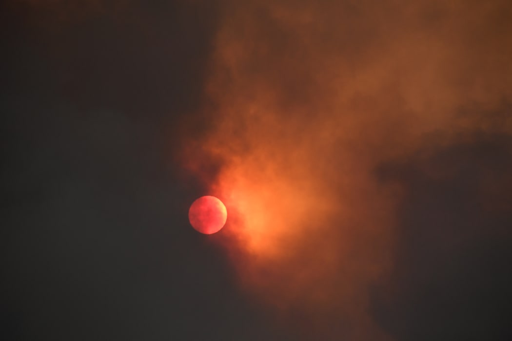 The sun is seen behind smoke from the Bobcat fire rising above in the Angeles National Forest above Duarte, California on 7 September, 2020.