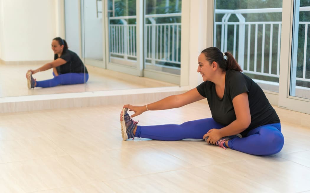 A woman stretching in a gym