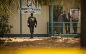 FBI agents are seen behind yellow crime scene tape outside Rancho Tehama Elementary School.