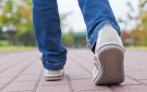 13409511 - teenager walking in sport shoes on pavement in autumn day