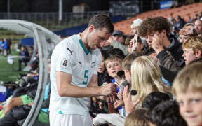 New Zealand's Chris Wood signs autographs.