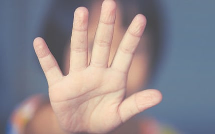 child with hand on window