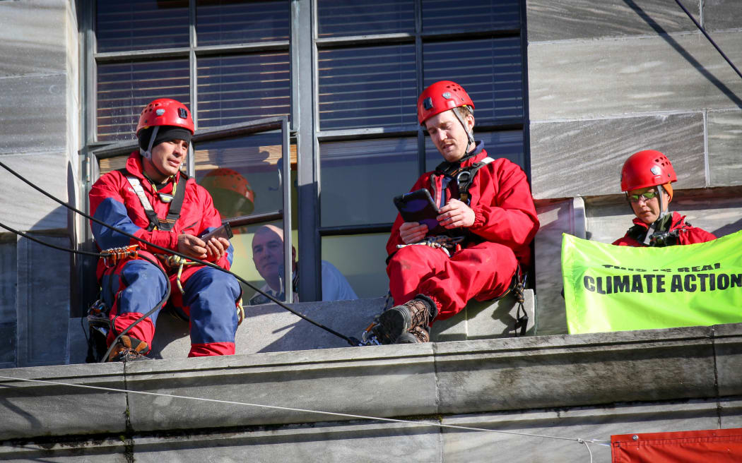 Security talking to protesters out of the window in parliament.